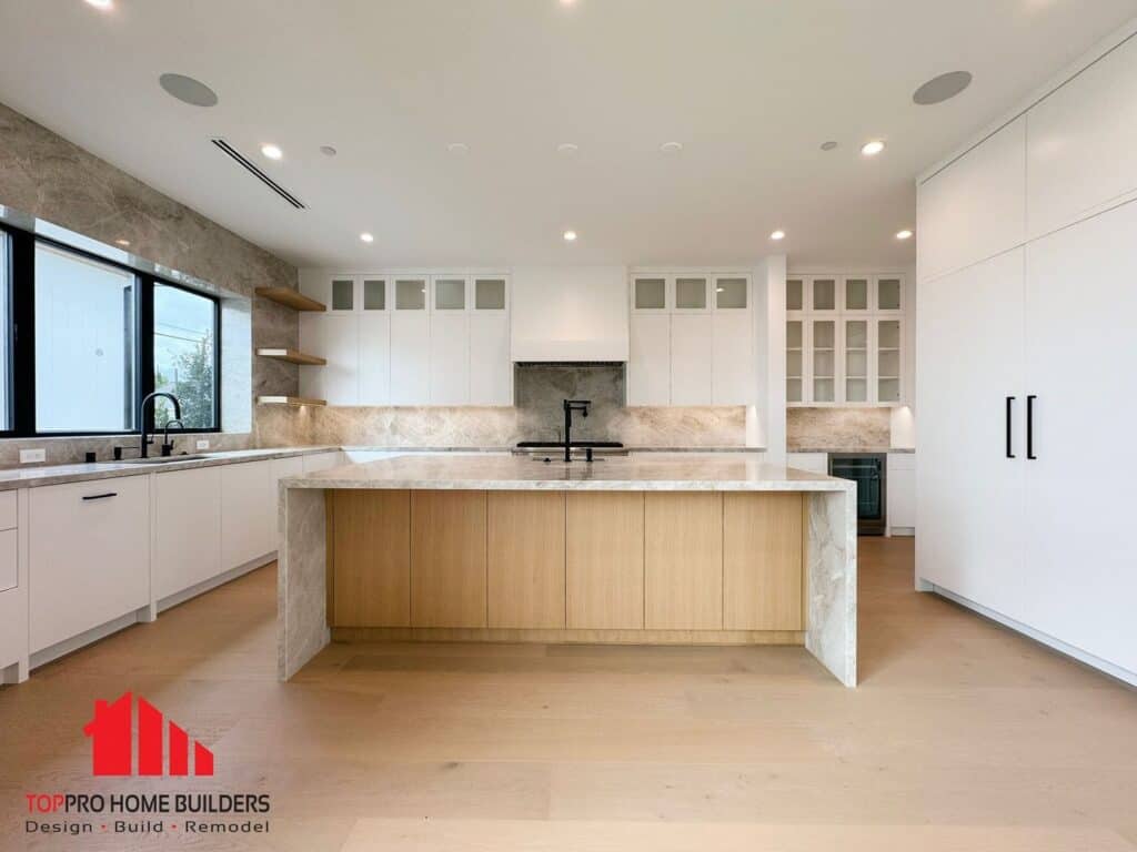 Image of a modern kitchen with marble countertops and white cabinetry.