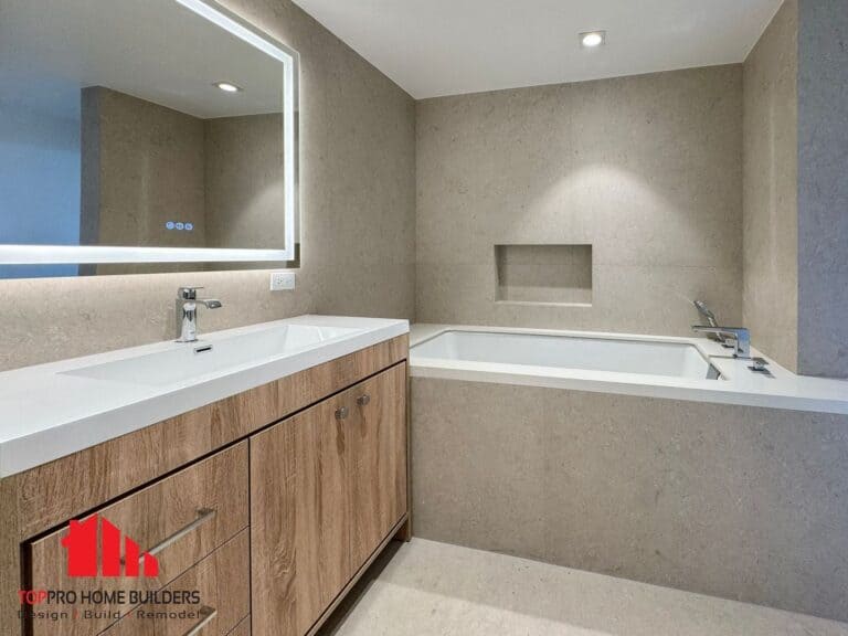 Bathroom with wooden vanity, LED mirror, and built-in bathtub.