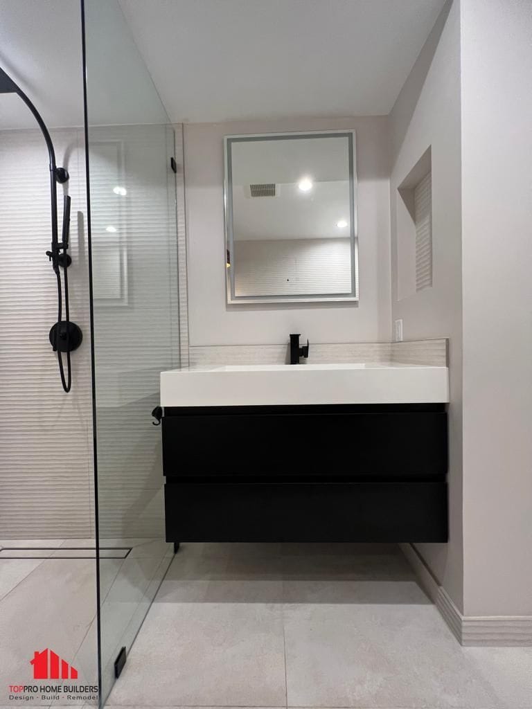 Image of a modern bathroom with glass shower and sleek vanity.