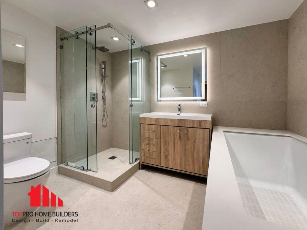 Modern bathroom with glass shower, wooden vanity, and bathtub.