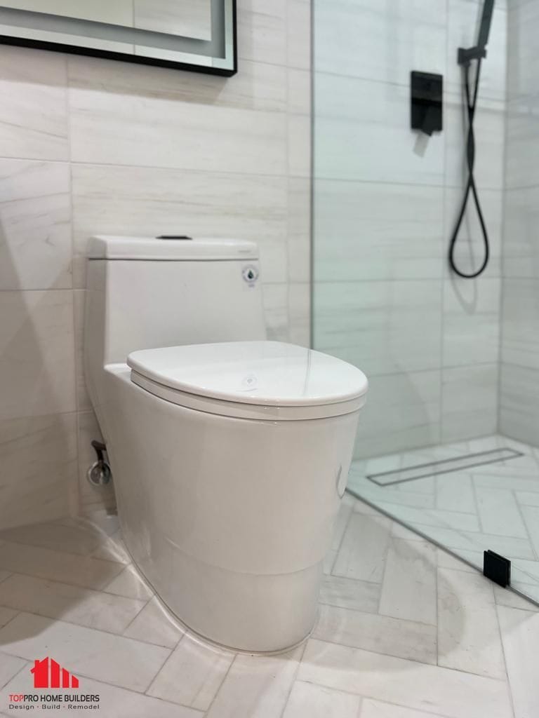 Image of a modern bathroom featuring a white toilet and glass shower enclosure.