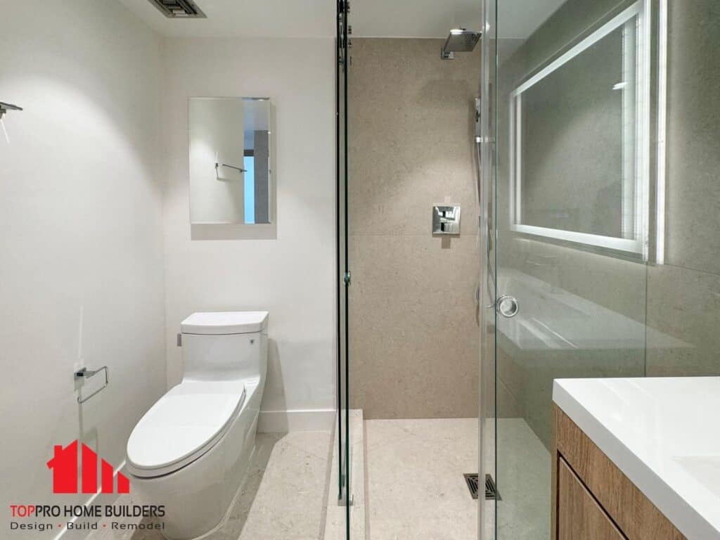 Modern bathroom with glass shower, integrated lighting mirror, and wooden vanity.