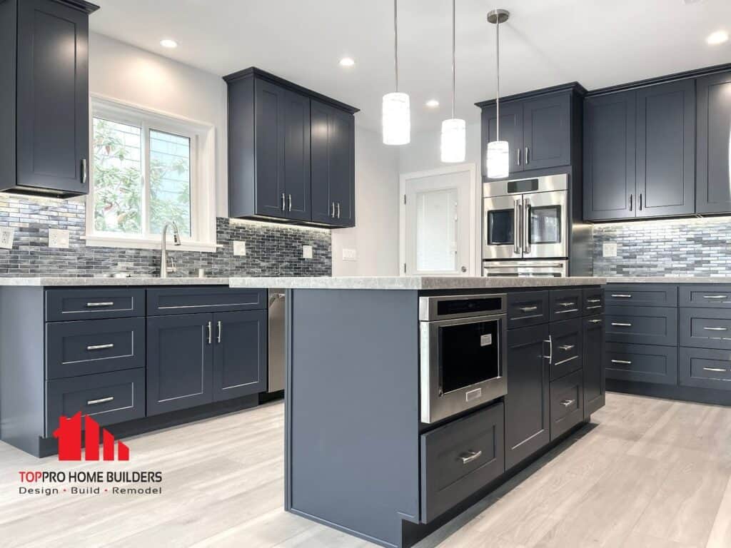 Image of a modern kitchen with dark blue cabinets, stainless steel appliances, and a mosaic backsplash.