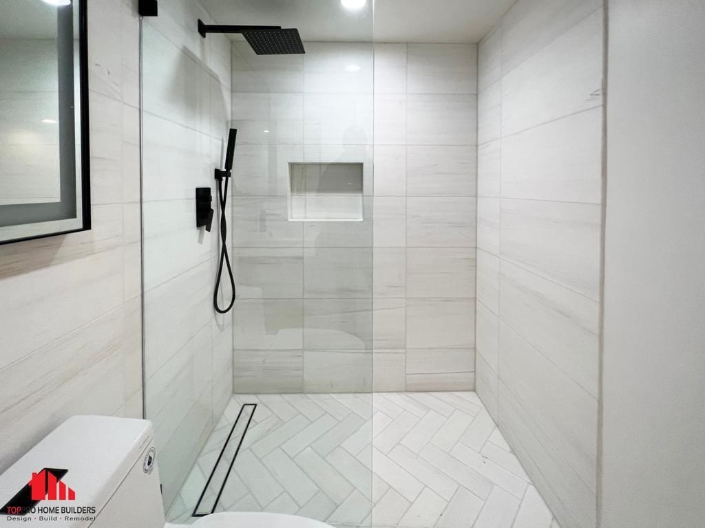 Image of a modern bathroom with a walk-in shower, featuring large tiles and a rainfall showerhead.