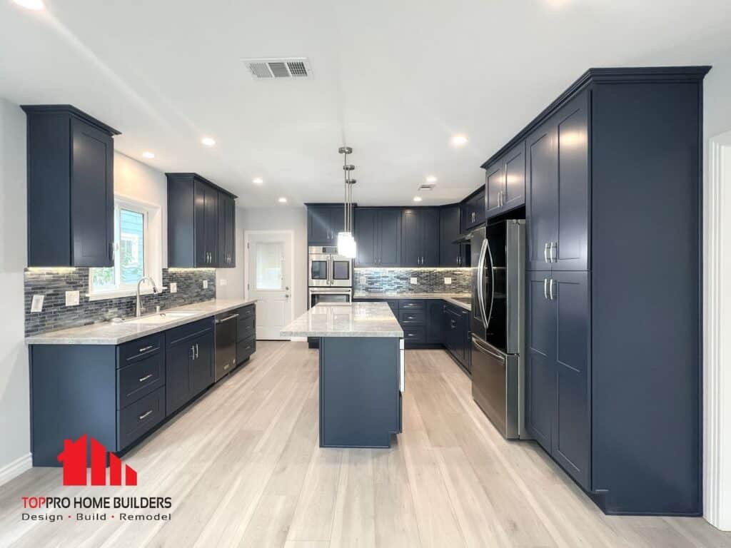 Image of a modern kitchen with dark blue cabinets, stainless steel appliances, and a central island.