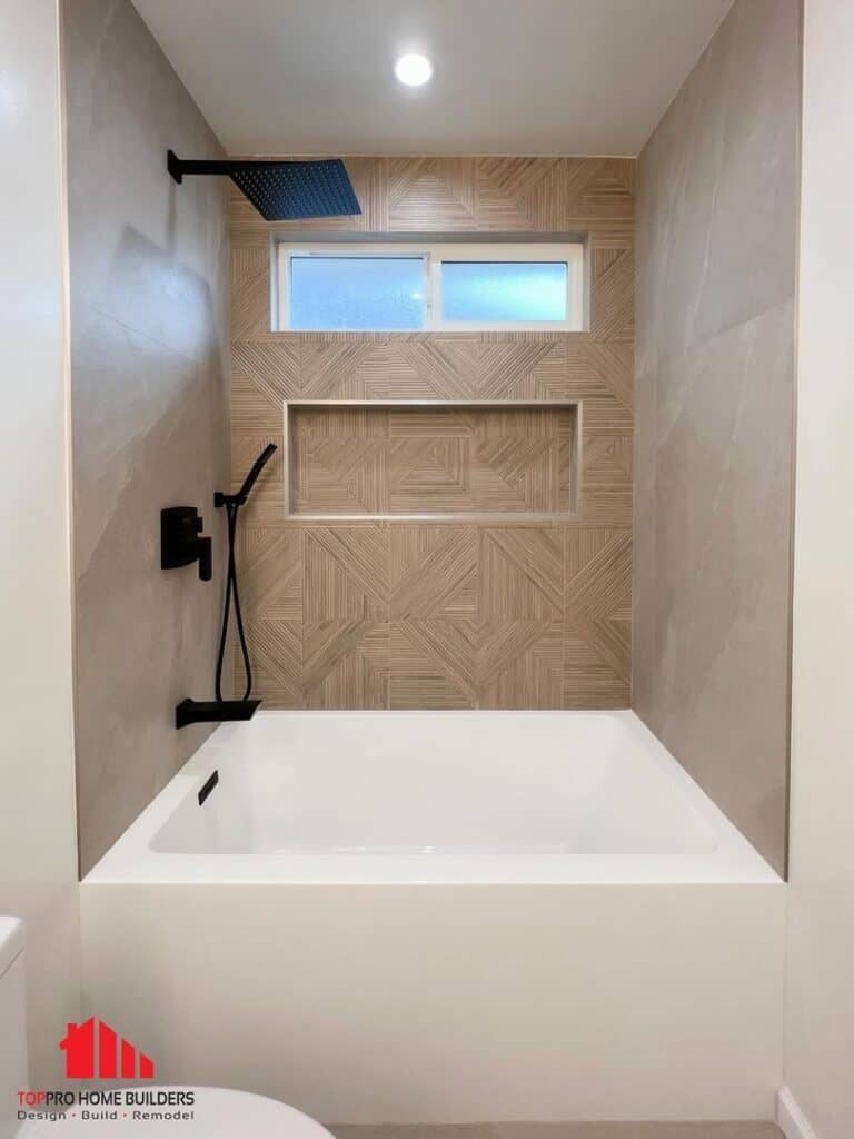 Bathroom with white tub, geometric tiles, black fixtures, and frosted window.