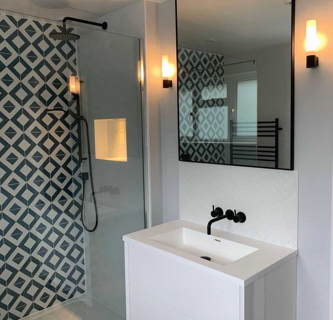 Modern bathroom with geometric tiles, glass shower, and sleek vanity.