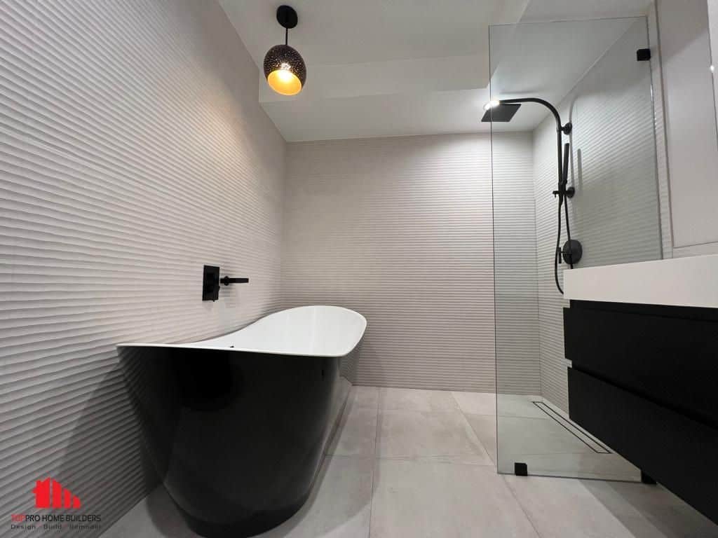 Image of a modern bathroom with a freestanding bathtub and glass-enclosed shower.