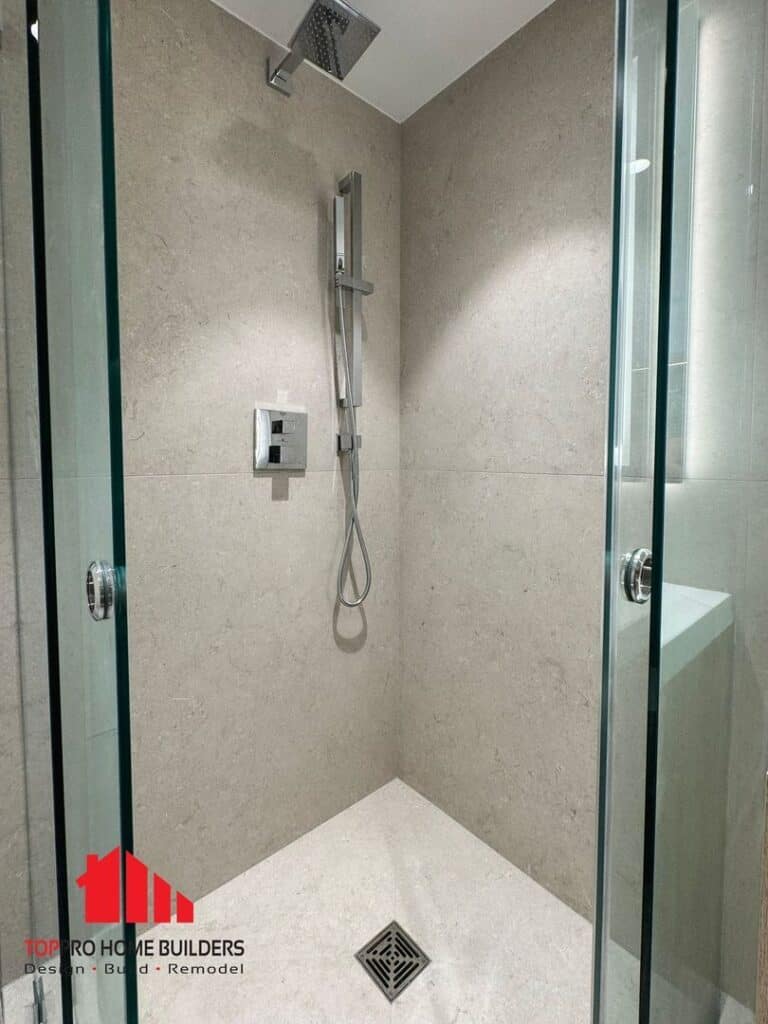 Image of a modern shower area with glass doors and fixtures.