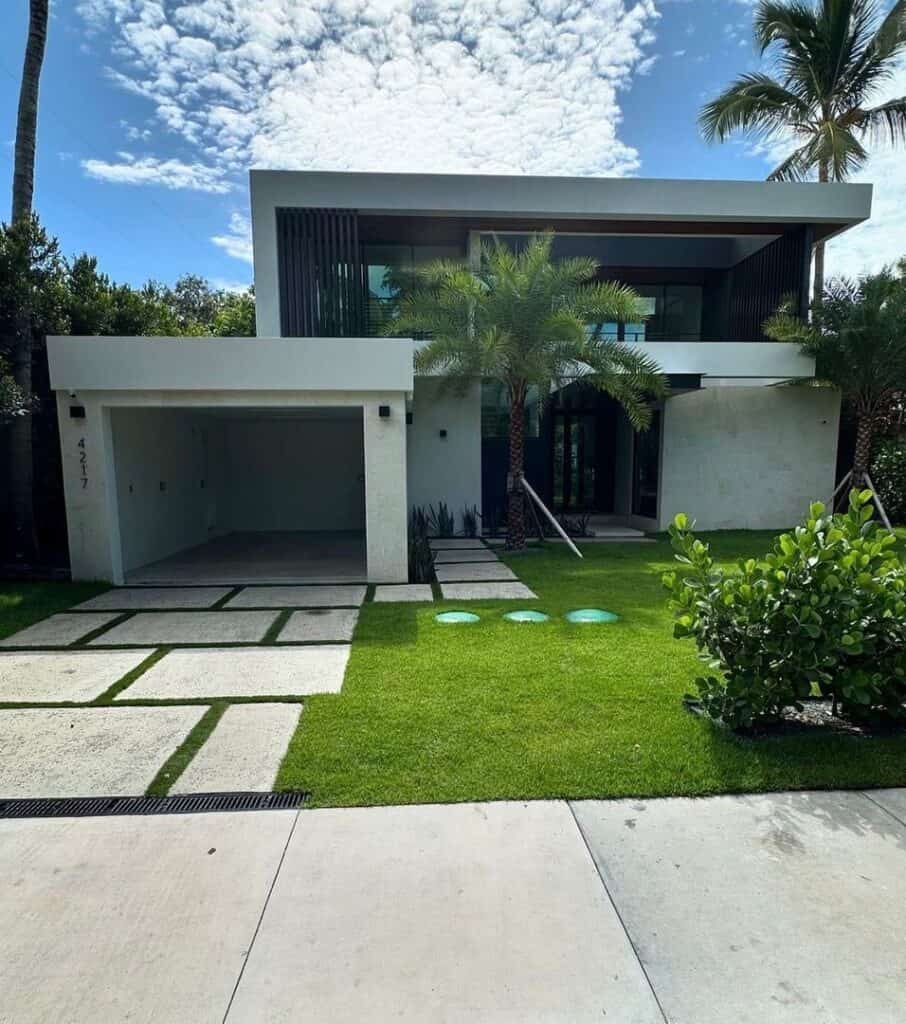 Modern two-story house with palm trees and a concrete pathway.