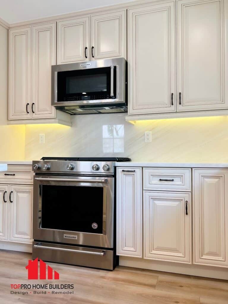 Image of a remodeled kitchen with stainless steel appliances and cream cabinetry.