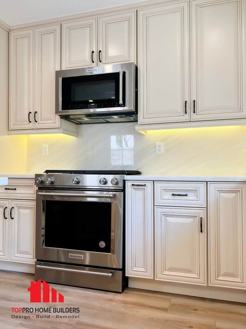 Image of a remodeled kitchen with stainless steel appliances and cream cabinetry.