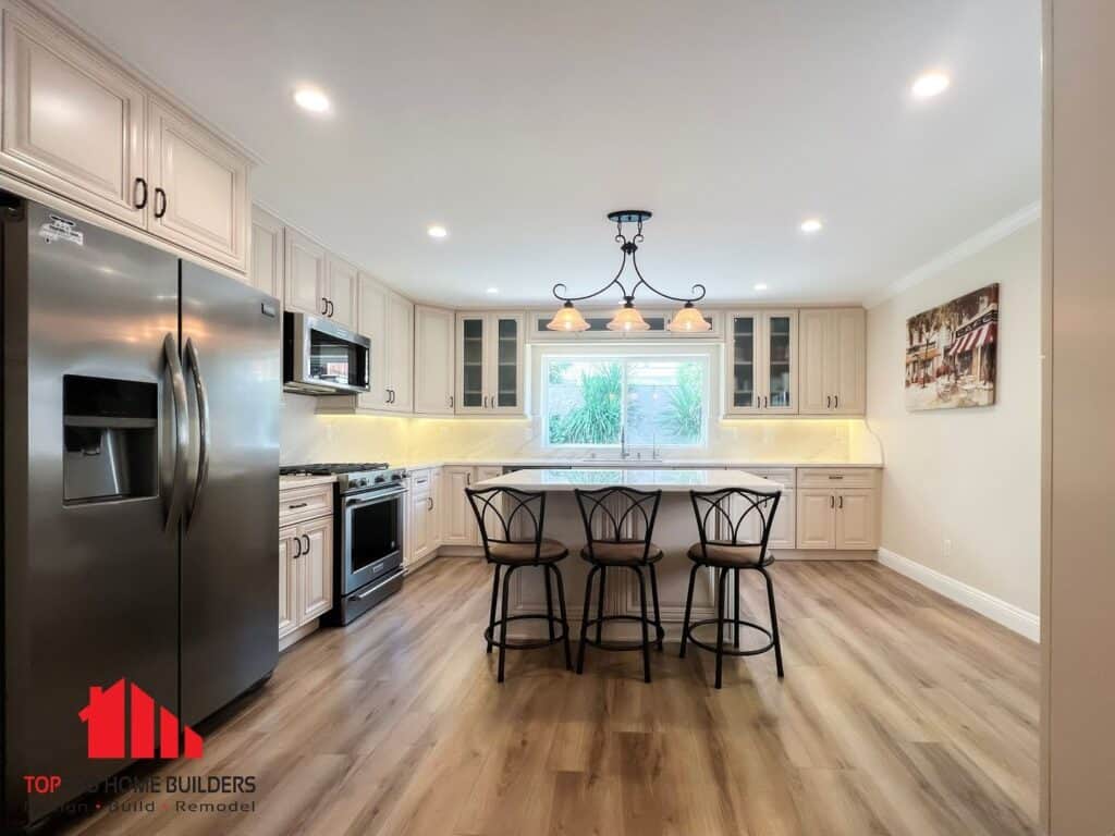 Image of a remodeled kitchen with stainless steel appliances and cream cabinetry.