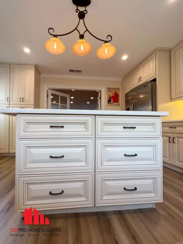 Remodeled kitchen with central island, overhead lighting, and stainless steel appliances.