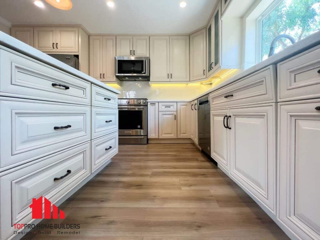 Modern kitchen with white cabinets and stainless steel appliances.