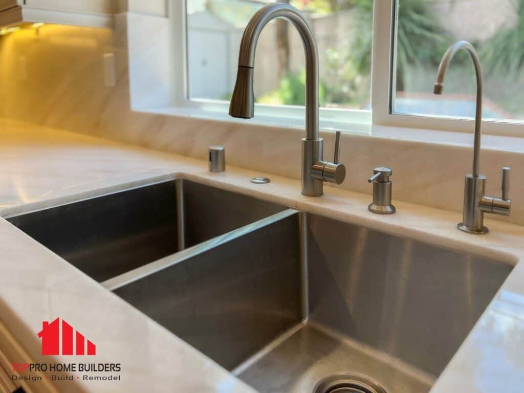 Modern dual-basin kitchen sink with metallic faucets and stone countertop.