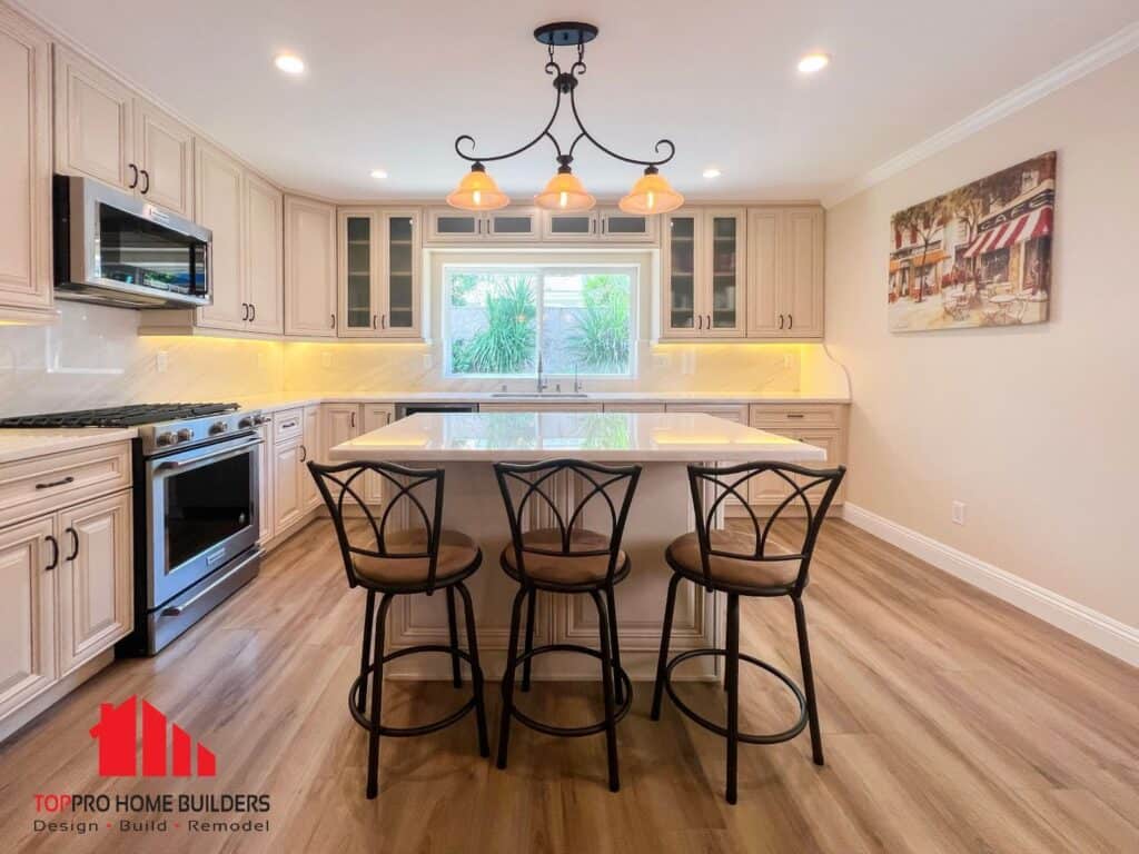 Image of a modern kitchen with light cabinets, central island, and stainless steel appliances.